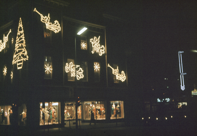 22279 Gezicht op het gebouw van kledingmagazijn Vinke (Vredenburg 40) te Utrecht, bij avond, met neon-verlichting ter ...